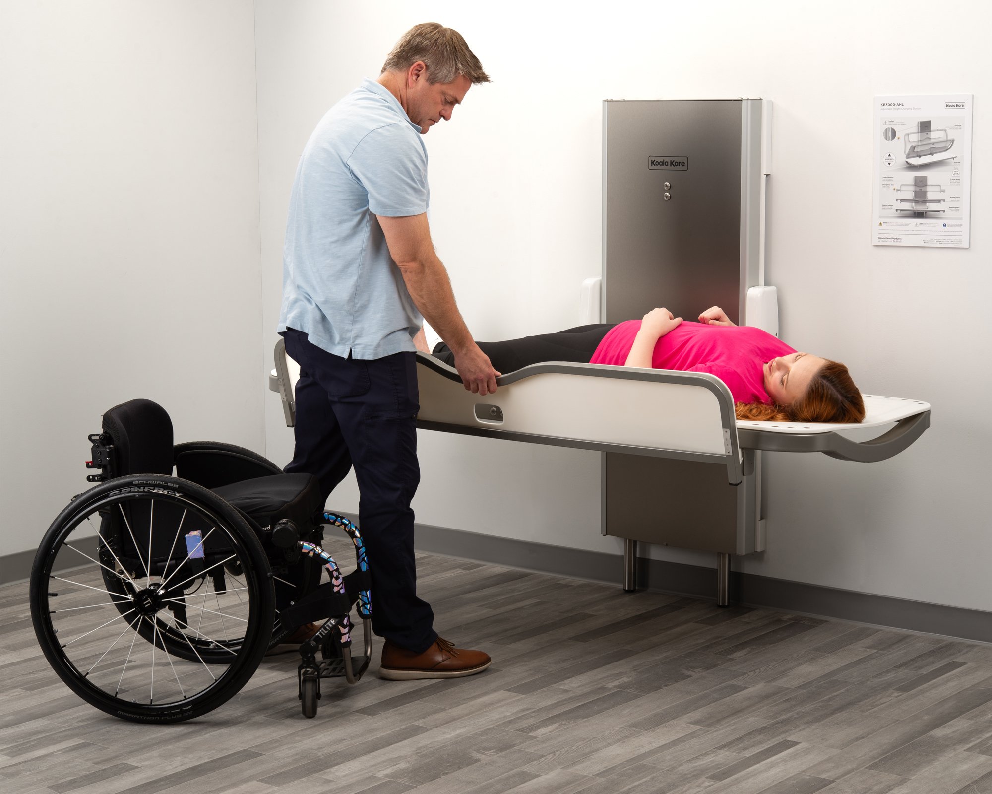 The Koala Kare KB3000-AHL Adjustable Adult Changing Station in use with a wheelchair for scale.