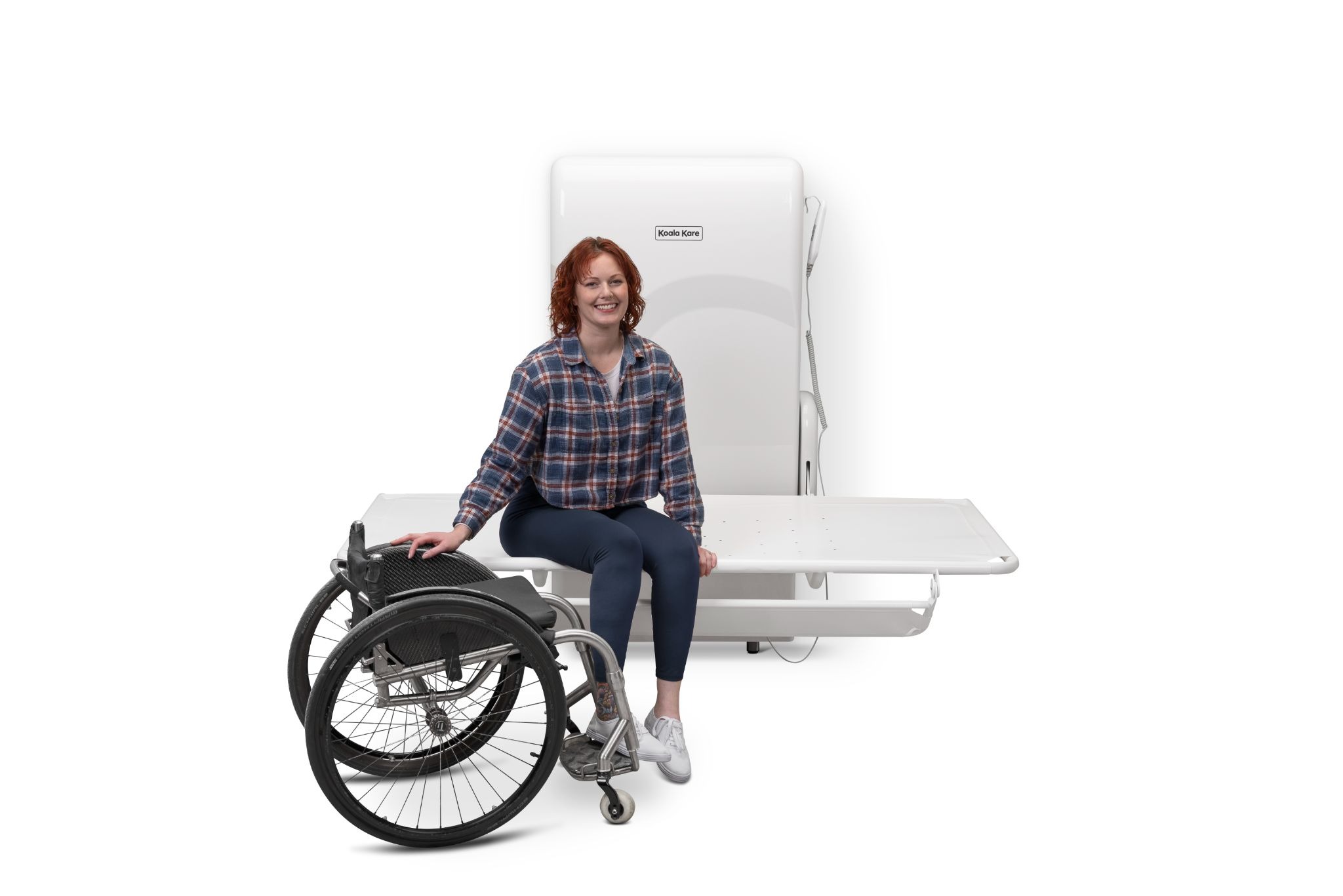 A woman sits on the lowered table of Koala Kare Products’ KB2600 Adult Changing Station.